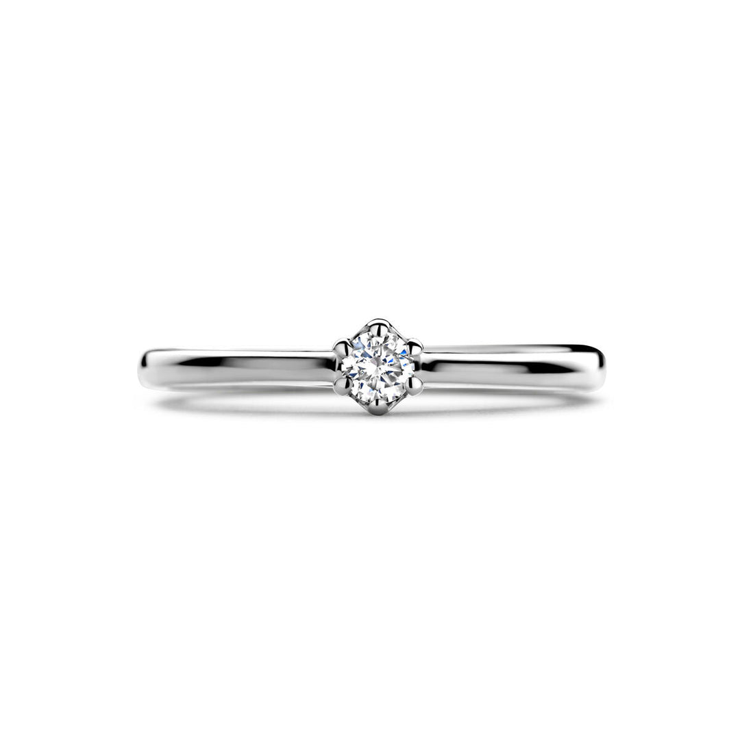 Een eenvoudige, elegante aanzoeksring diamant 0,10ct H SI in 14K witgoud van Van der Kooij Collectie, met een enkele ronde diamanten solitaire in een klassieke griffenzetting tegen een effen witte achtergrond.