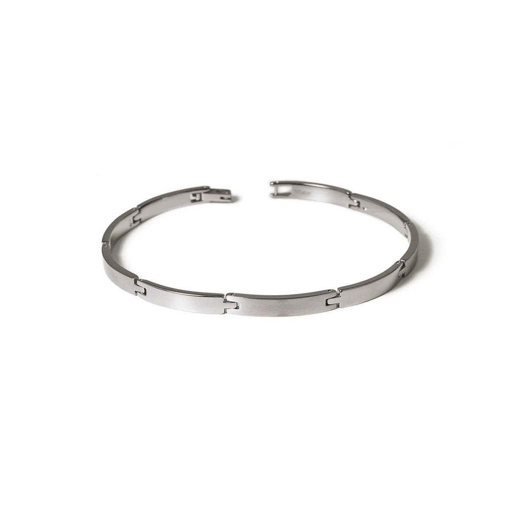 De Boccia Titanium Armband 0319-03 heeft een strak, gesegmenteerd schakelontwerp en een gebogen, minimalistische vorm. Deze zilveren damesarmband van Boccia wordt open weergegeven tegen een effen witte achtergrond.