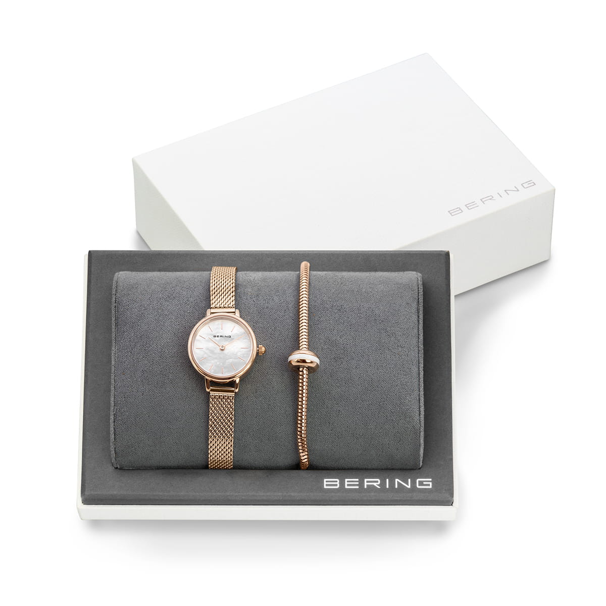 Montre en acier inoxydable doré rose avec cadran blanc, accompagnée d'un bracelet jonc doré rose.
