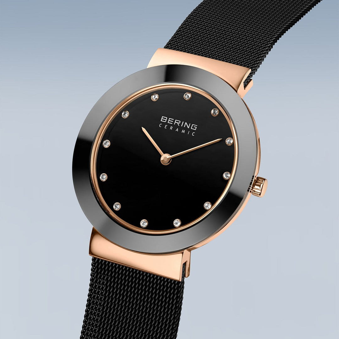 De Bering 11435-166 is een luxe polshorloge met een zwarte ronde wijzerplaat, minimalistisch design en diamantachtige uurmarkeringen. De goudkleurige kast en zwarte meshband versterken de elegantie, terwijl Bering Ceramic op de wijzerplaat het vakmanschap van saffierglas benadrukt.