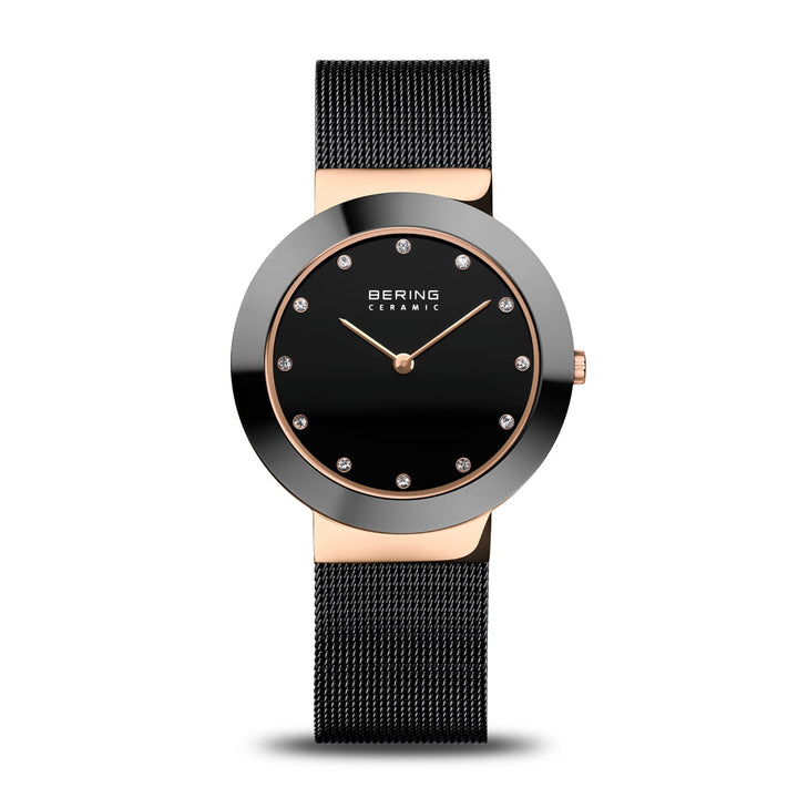 Het Bering 11435-166 horloge heeft een zwarte mesh band, zwarte ronde wijzerplaat met Saffierglas, kristallen uurmarkeringen en gouden wijzers. Het is gelabeld als BERING CERAMIC en bevat Quartz-uurwerk voor nauwkeurige tijdwaarneming.