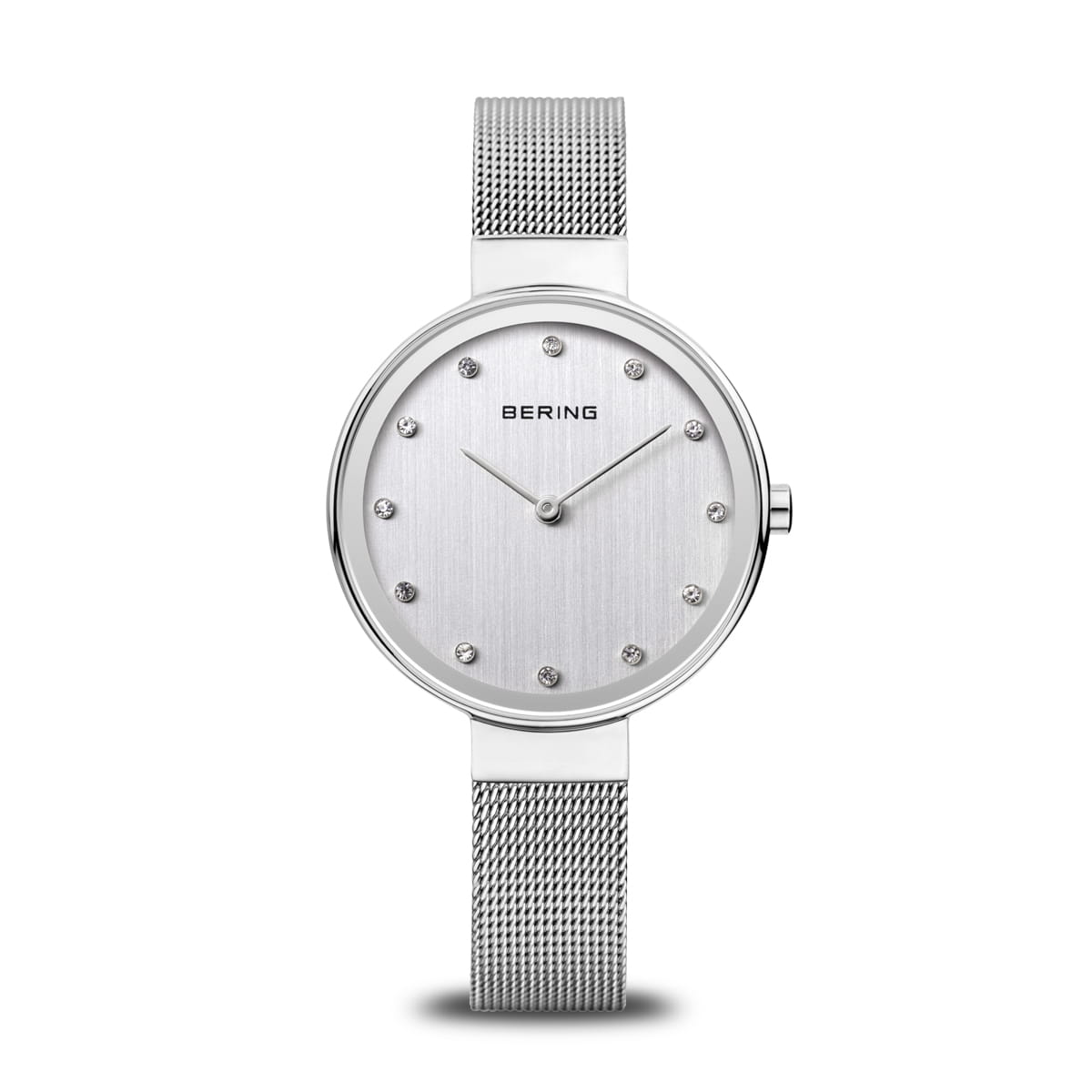 Montre argentée avec un cadran lisse et des index en strass, bracelet en maille métallique.