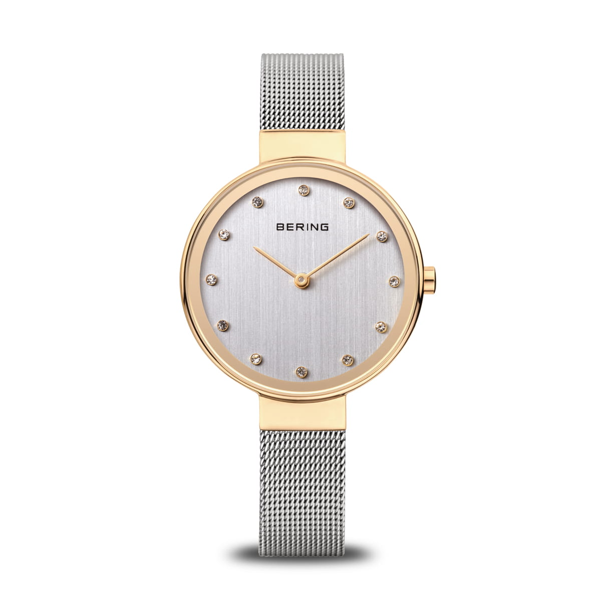 Montre femme avec cadran argenté, boîtier doré et bracelet en maille métallique.