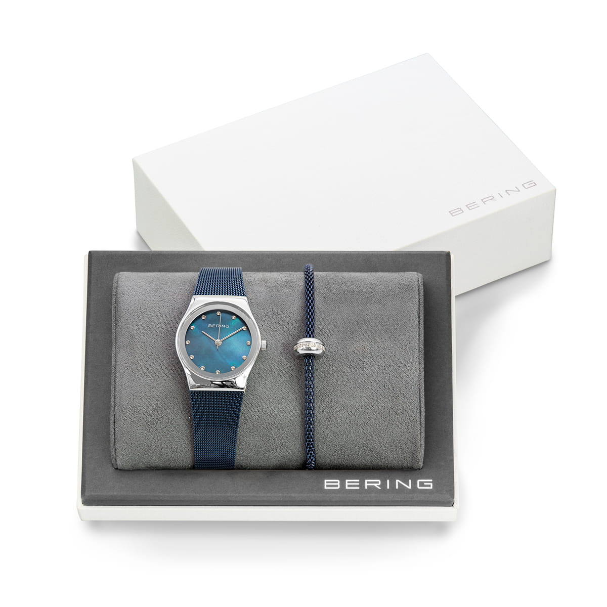 Montre avec cadran bleu et bracelet en silicone, accompagnée d'un bracelet jonc argenté.