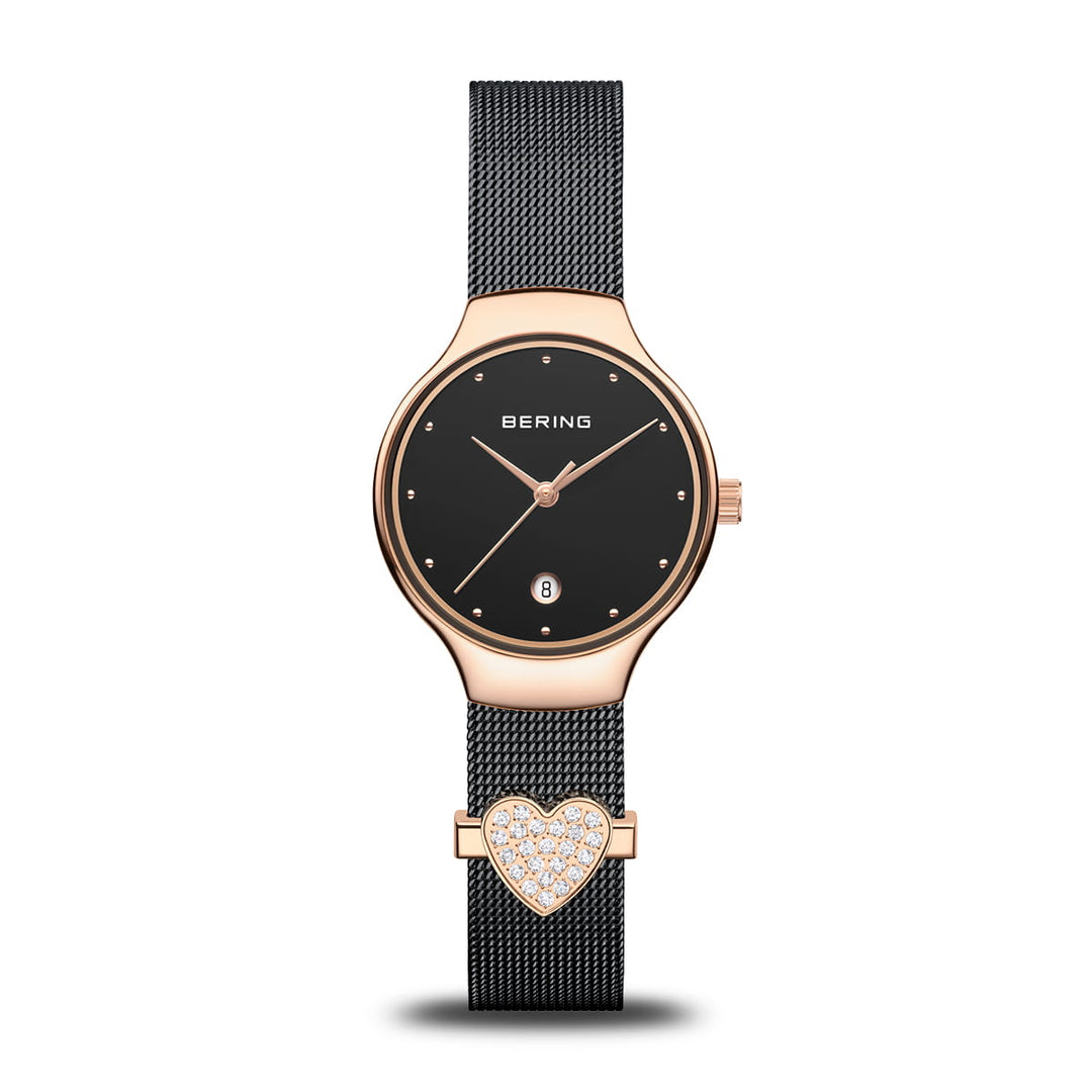 De Bering 13326-262-GWP, een quartz dameshorloge, heeft een ronde zwarte wijzerplaat en een zwarte mesh band. De roestvrijstalen kast en lunette hebben een elegante roségouden afwerking, aangevuld met een hartvormige kristallen bedel voor extra verfijning.