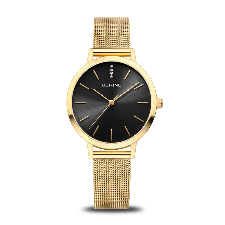 De Bering dames horloge zwarte wijzerplaat 13434-332 heeft een gouden kast, minimalistische gouden uurmarkeringen, saffierglas, vier ronde accenten op 12 uur en een goudkleurige Milanees band. Merk: Bering.
