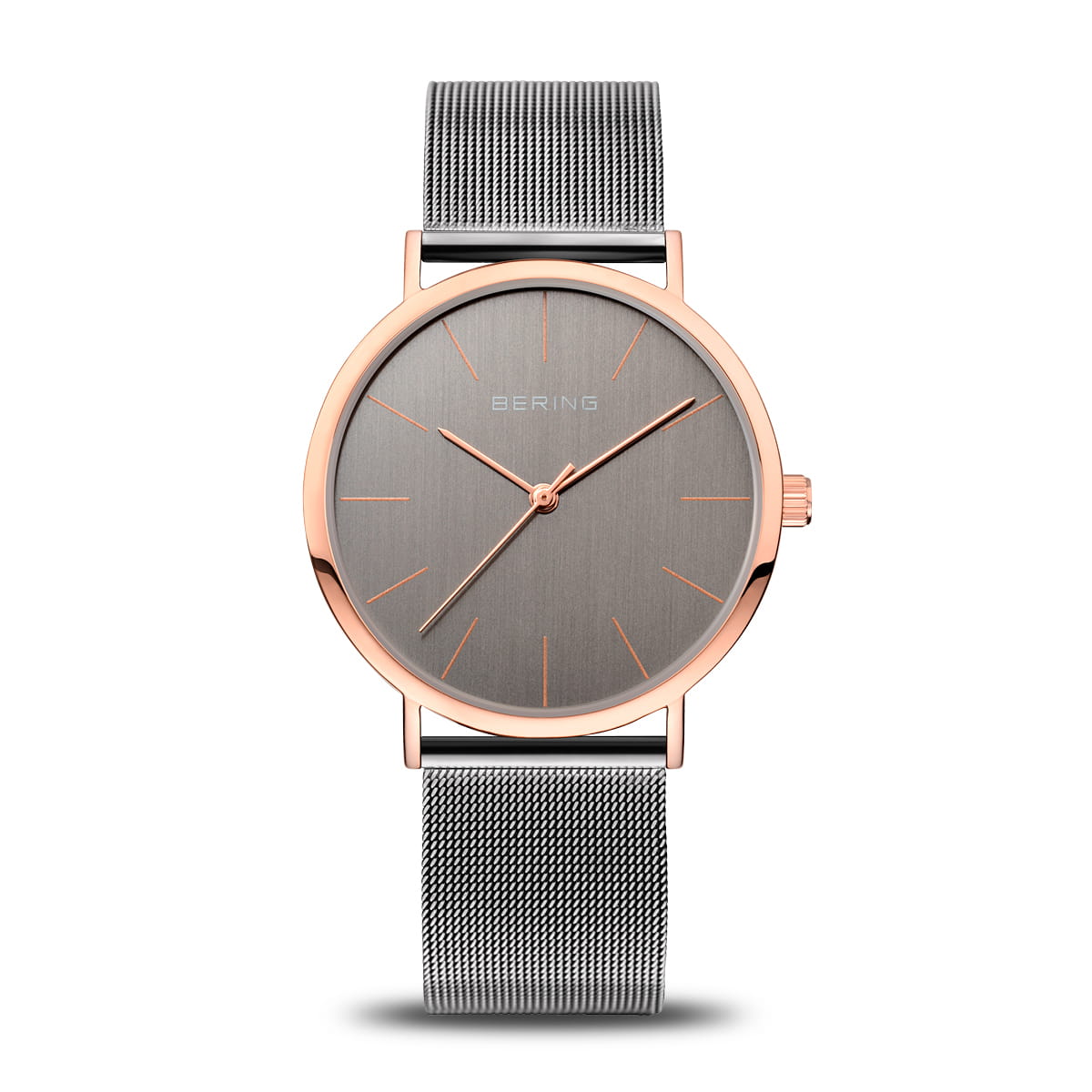 Montre avec boîtier rose doré, cadran gris et bracelet en maille métallique.