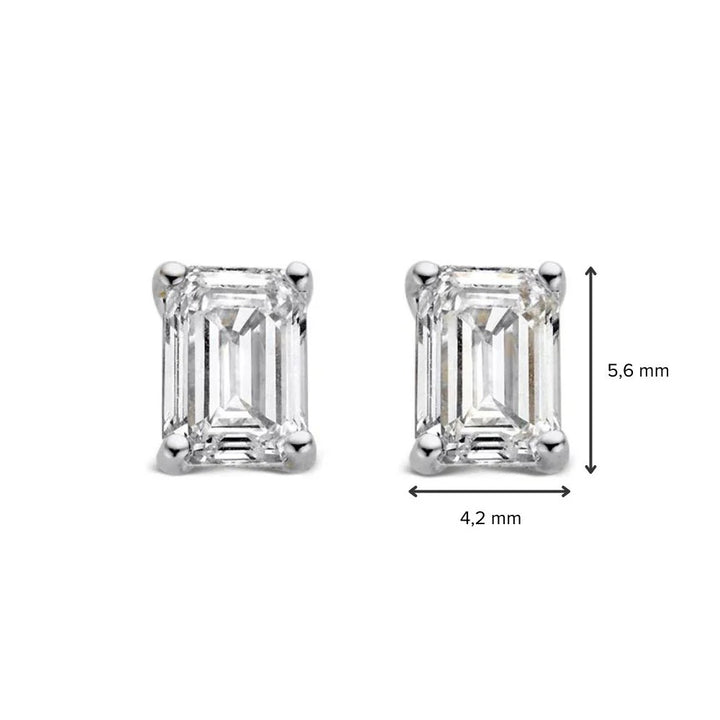 Oorstekers Nora van Aurore Jewelry in witgoud, 1,00 crt.: rechthoekige oorbellen met smaragd en diamant, elk met vier pootjes, gezet in witgoud, naast elkaar afgebeeld op een witte achtergrond. Afmetingen: 5,6 mm x 4,2 mm.