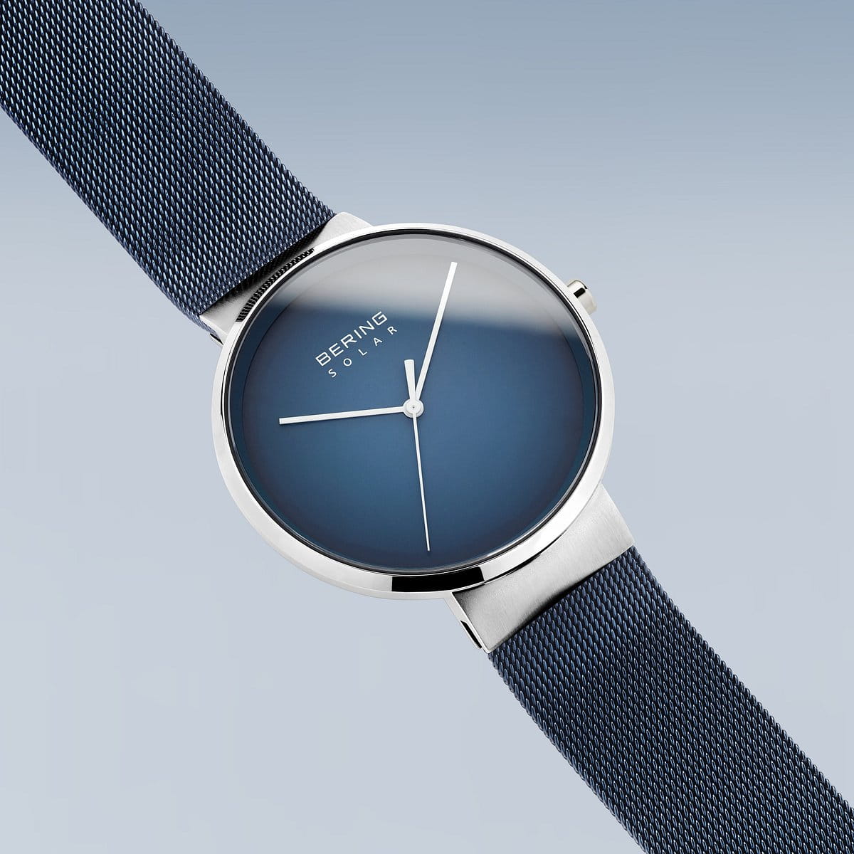 Het Bering unisex horloge 14339-307 heeft een strak, minimalistisch design met een blauwe wijzerplaat en zilveren kast, aangevuld met een blauwe mesh band. Een elegant accessoire voor liefhebbers van moderne stijl.
