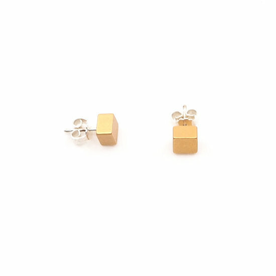 Boucles d'oreilles en forme de cube abricot avec finition brillante.