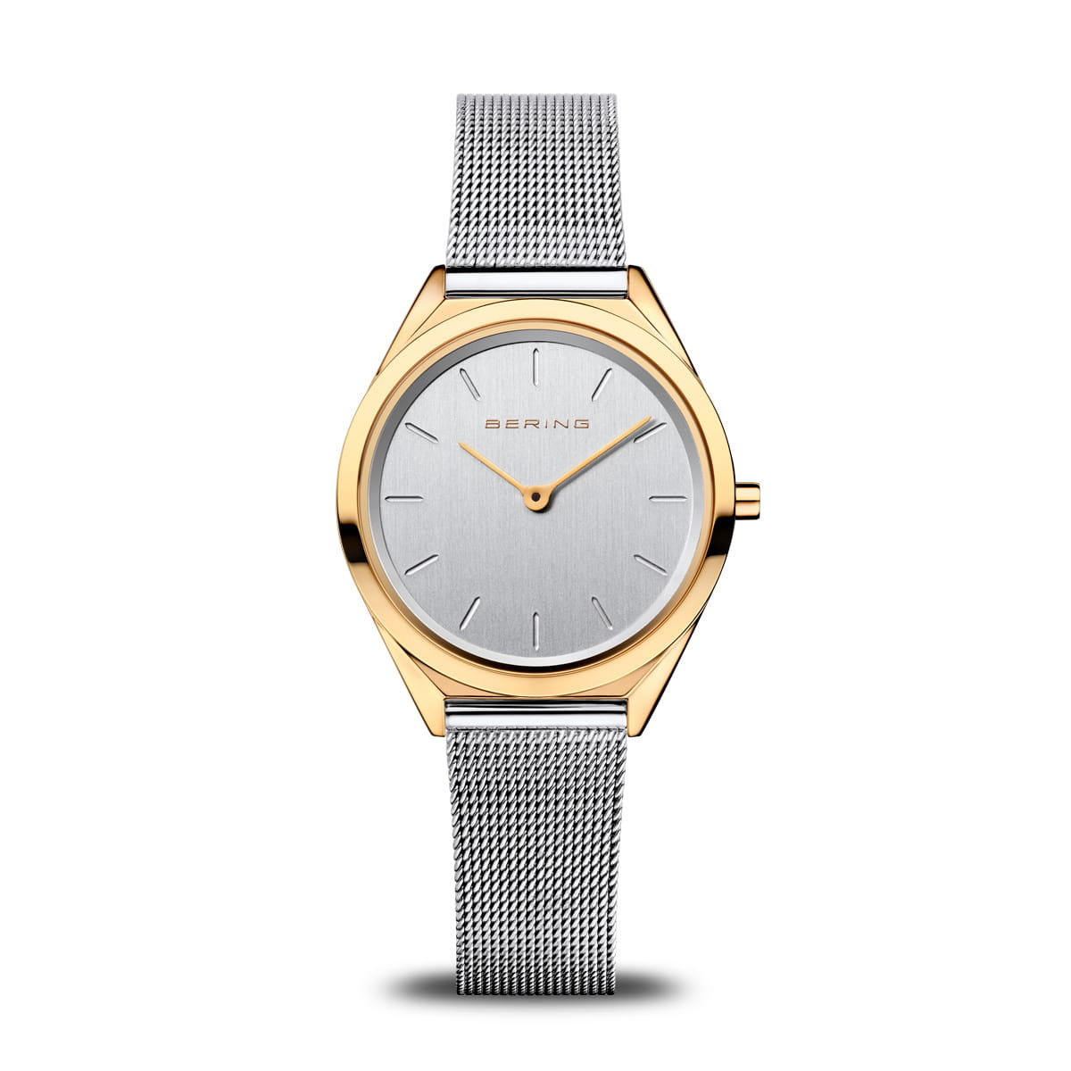 Montre pour dames avec cadran argenté, boîtier doré et bracelet en maille.