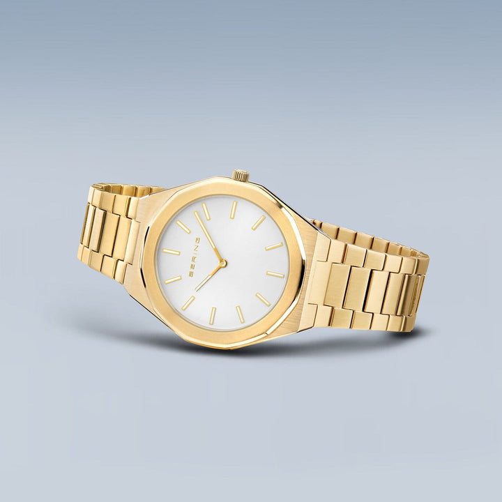 Het Bering herenhorloge model 19641-730 heeft een strak ontwerp met een zilveren wijzerplaat, minimalistische gouden uurmarkeringen en een goudkleurige roestvrijstalen band, waardoor een elegante en moderne uitstraling ontstaat.