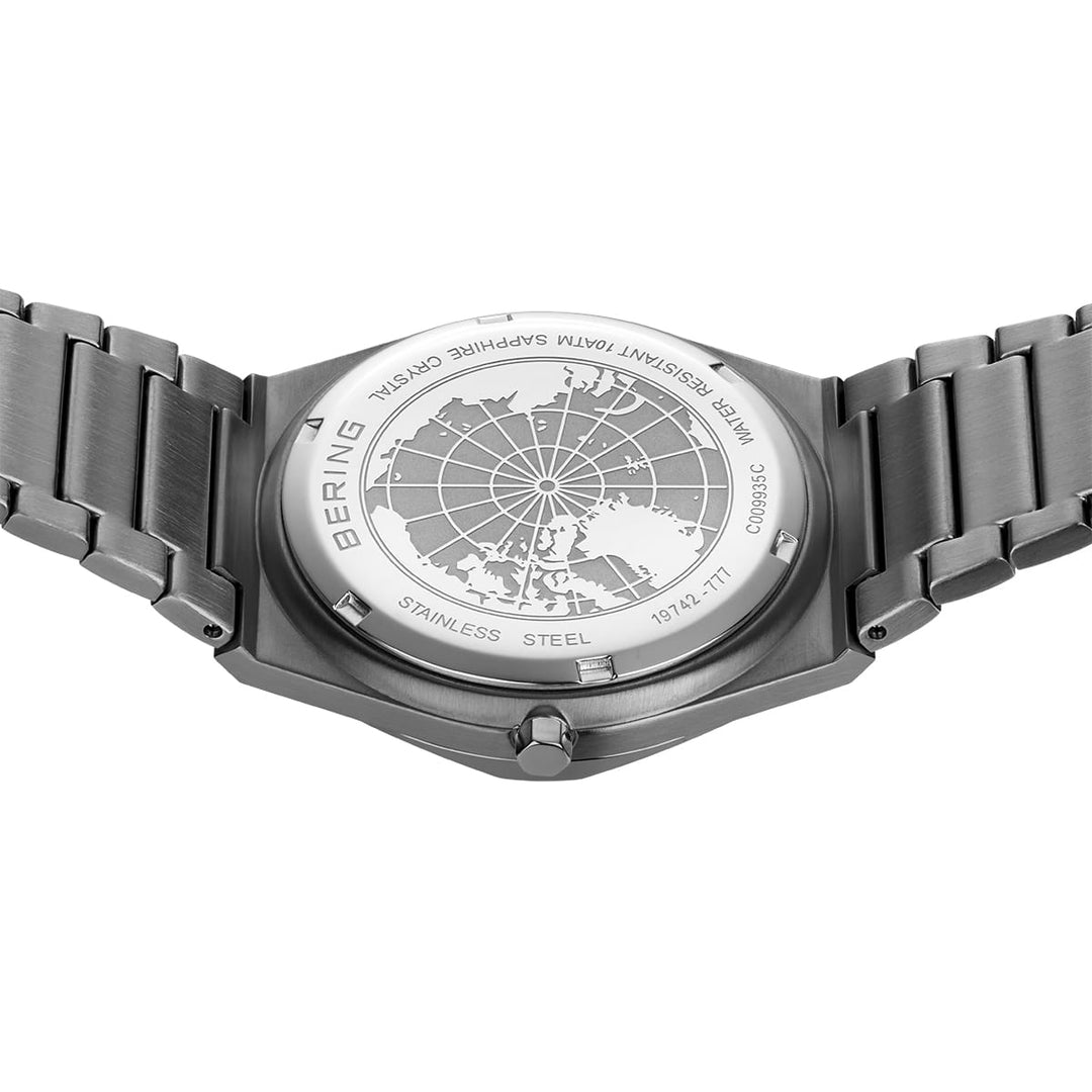 De afbeelding toont de achterkant van het Bering heren horloge grijze wijzerplaat - 19742-777, dat is gemaakt van roestvrij staal met een gegraveerd ontwerp van een kaart van het Noordpoolgebied, aangevuld met een metalen schakelband en markeringen voor waterbestendigheid en saffierglas.