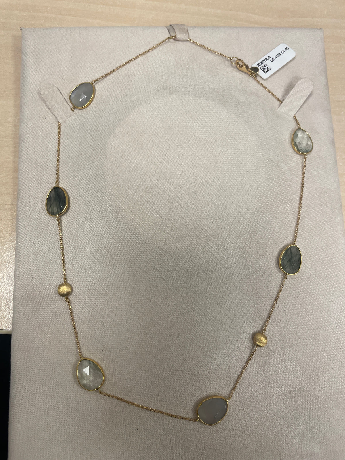 Collier doré avec des pierres semi-précieuses ovales et un design délicat.