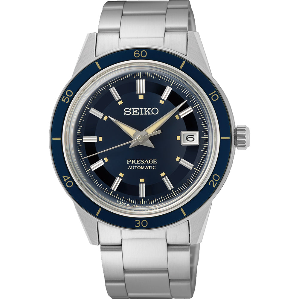 De Seiko Prospex SRPG05J1 is een prachtig herenhorloge met een zilveren band, een donkerblauwe wijzerplaat met lichtgevende wijzers en een datumweergave op 3 uur, samen met een blauwe lunette met minutenmarkeringen, alles gevat in roestvrij staal.