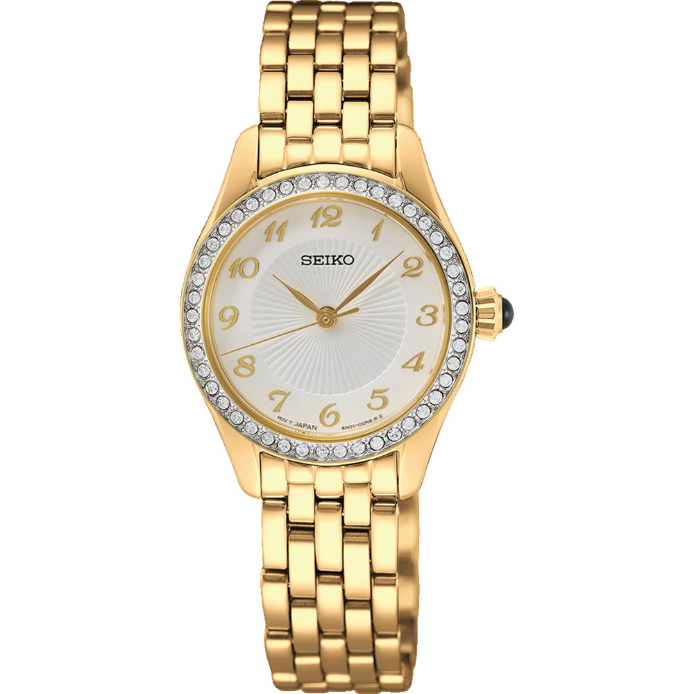 Het Seiko dameshorloge SUR388P1 is een prachtig gouden polshorloge met een ronde wijzerplaat, witte wijzerplaat met gouden Arabische cijfers en heldere stenen op de lunette. Het heeft een quartz uurwerk en gouden schakelband, geaccentueerd door een groene steen op de kroon voor extra elegantie.