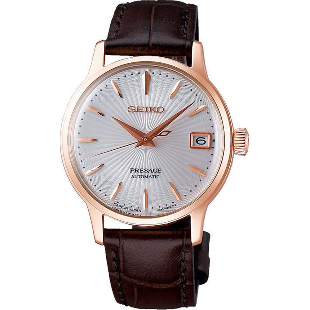 Montre Seiko Presage pour femme avec cadran argenté, boîtier rose et bracelet en cuir marron.