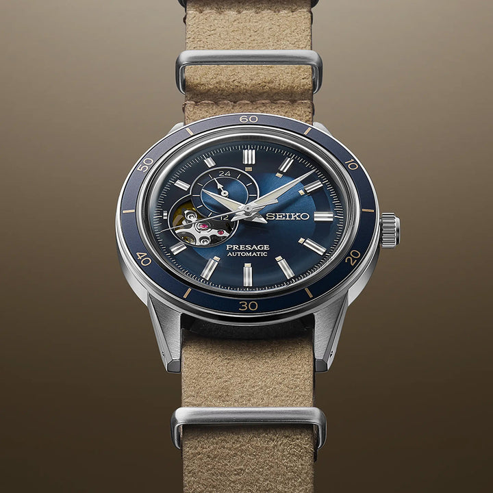 Het Seiko Presage heren horloge SSA453J1 heeft een blauwe metalen wijzerplaat, zichtbare tandwielen en een beige leren band. Het open-hart ontwerp versterkt de strakke bruine achtergrond en wordt beschermd door Hardlex mineraal glas—een prachtig automatisch horloge om elke outfit te verheffen.
