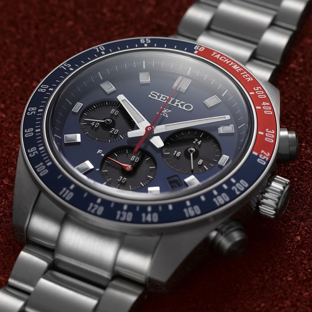 Het Seiko Prospex herenhorloge SSC913P1 heeft een rood oppervlak met structuur en is voorzien van een roestvrijstalen band, een blauwe en rode lunette, een donkere wijzerplaat met drie subwijzerplaten, zilveren uurmarkeringen en een zonne-uurwerk dat de nauwkeurige tachymeterschaal aandrijft.