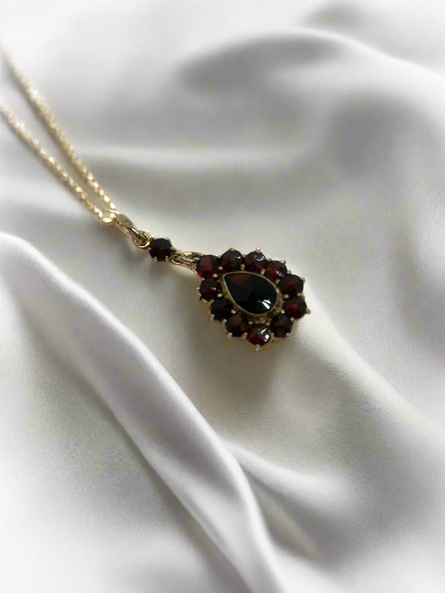Pendentif vintage en or 14k avec grenat, décoré de pierres rouges et en forme de goutte.