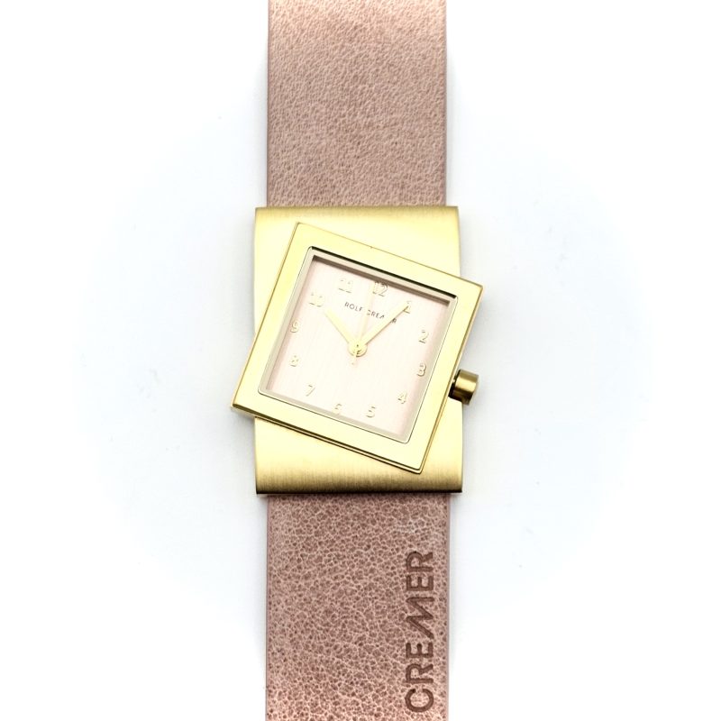 Montre carrée dorée avec un cadran rose et un bracelet en cuir beige.