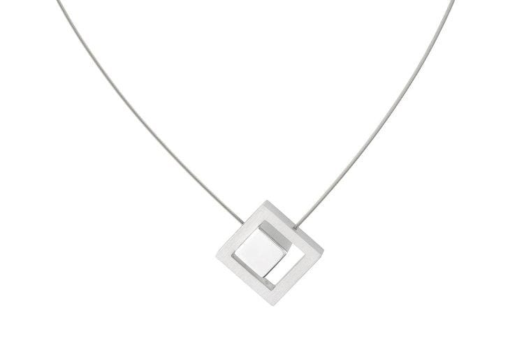 Collier en argent avec pendentif en forme de cube carré.