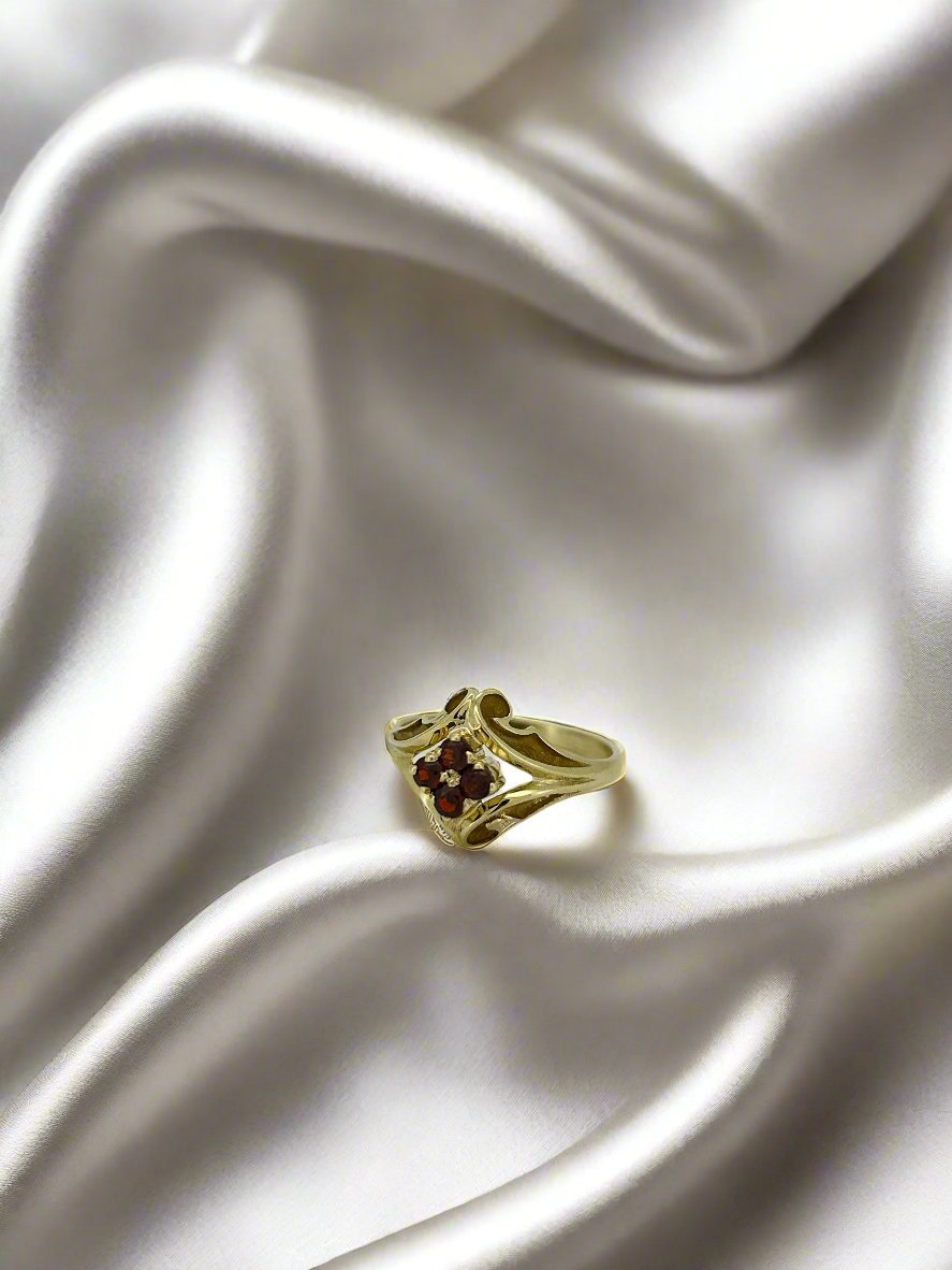 Bague vintage en or jaune 14 carats ornée de grenats rouges.