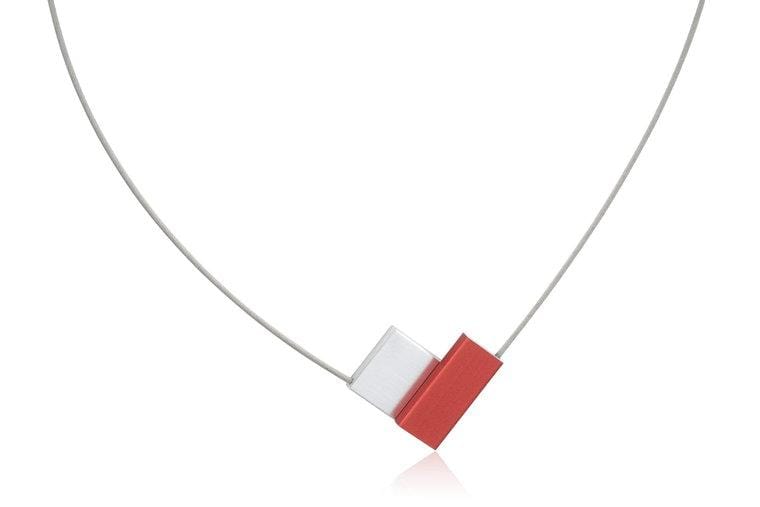Collier en V avec des éléments rouges et blancs sur un fil métallique.