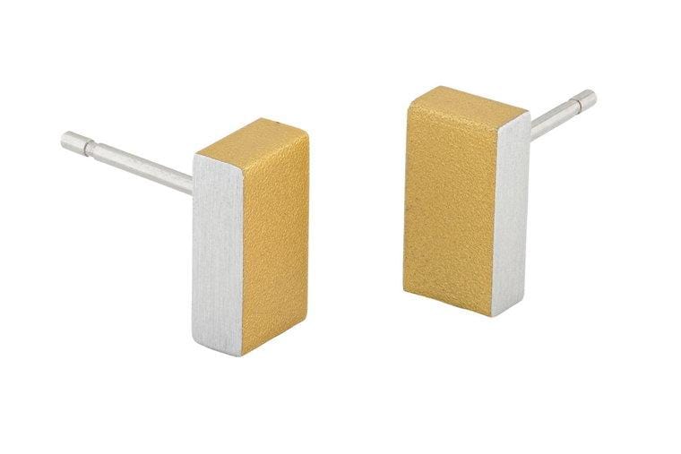 Boucles d'oreilles rectangulaires en métal doré avec une finition mate et une tige en argent.