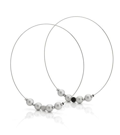 Collier en perles argentées avec des perles noires, monté sur fil métallique.