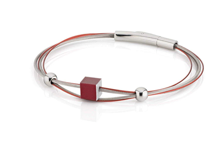 De Armband kubusje Rood A230R van CLIC Creations toont twee strakke, metalen banden—zilver en rood—versierd met een rode kubus en twee zilveren kralen. De glanzende, metalen bajonetsluiting complementeert de hypoallergene zilveren band perfect.
