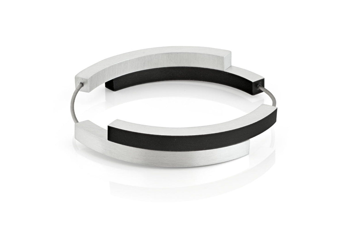 Bracelet en métal argenté avec quatre arcs noirs.