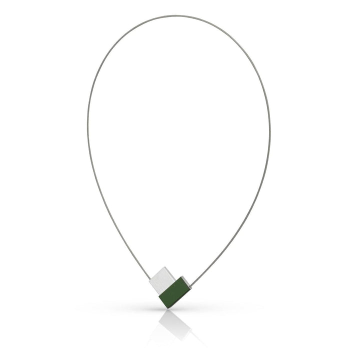 De Collier V-vorm Groen C150GR van CLIC Creations is een minimalistische ketting met een dunne metalen draad in een traanvorm. Het heeft een geometrische hanger met afwisselende groene en zilveren segmenten, wat een moderne touch toevoegt aan het unieke ontwerp. Handgemaakt in Nederland, het werpt subtiele reflecties naar beneden.