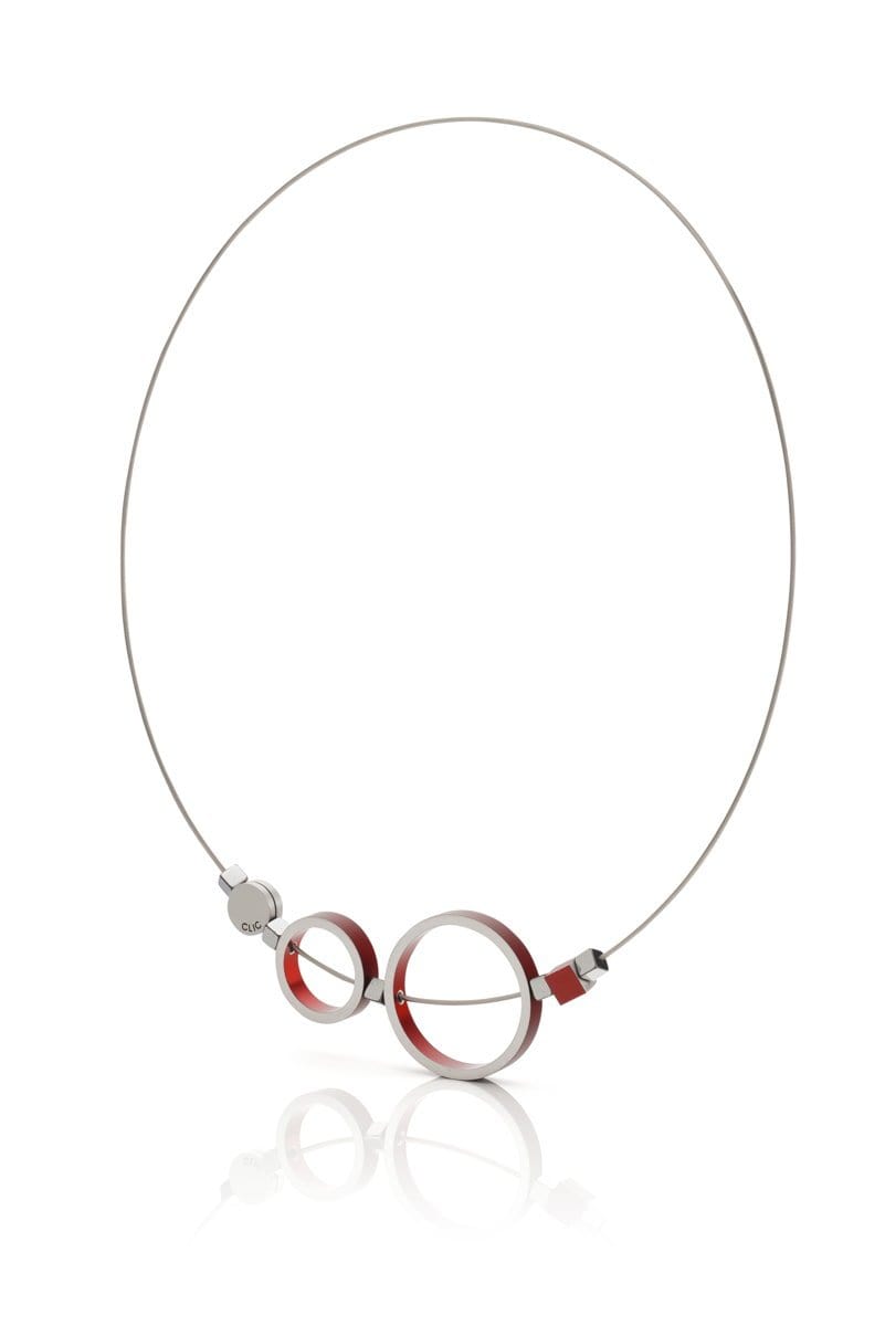 Collier en acier inoxydable avec deux anneaux rouges et un détail argenté.