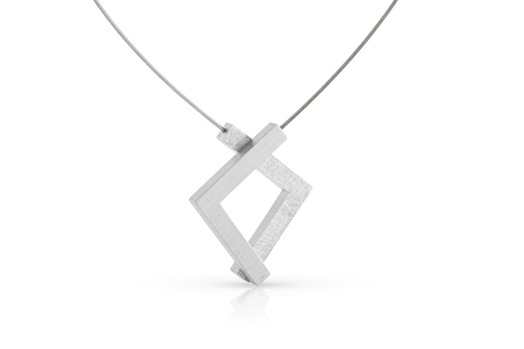 De Collier van twee hoekjes C217 van CLIC Creations is een moderne zilveren ketting met een geometrische, ruitvormige hanger van kruisende rechthoeken aan een fijne draadketting, met een minimalistisch ontwerp en magnetische sluiting voor eenvoudig dragen.