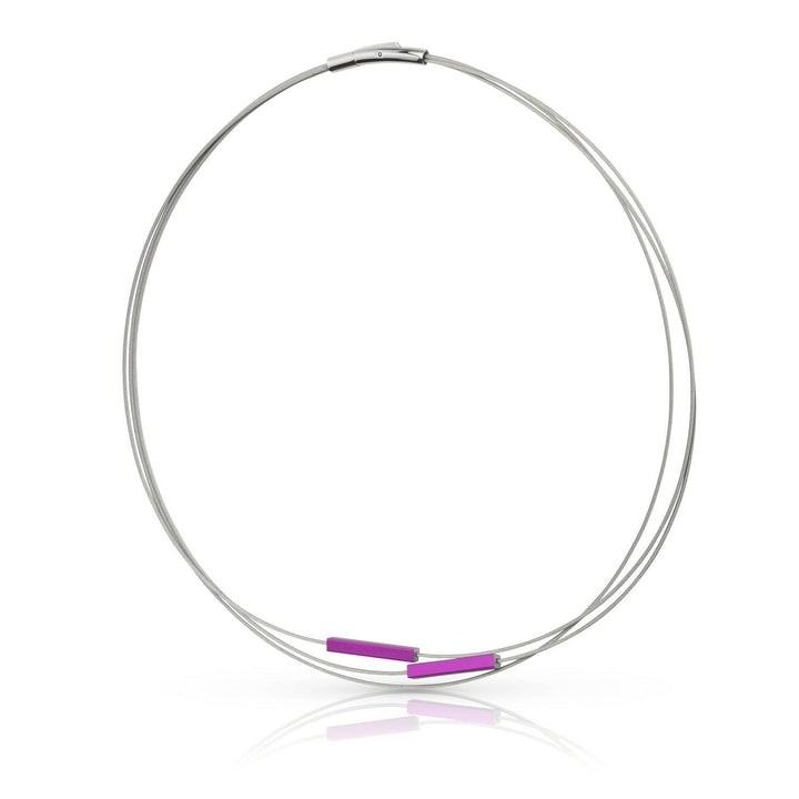 De Collier Staafjes Paars C243P van CLIC Creations is een eenvoudige zilveren ketting, handgemaakt in Nederland, met een strak draadontwerp en twee kleine paarse kraaltjes bij de sluiting, opgerold voor een strakke en minimalistische look die zachtjes licht weerkaatst op een witte achtergrond.