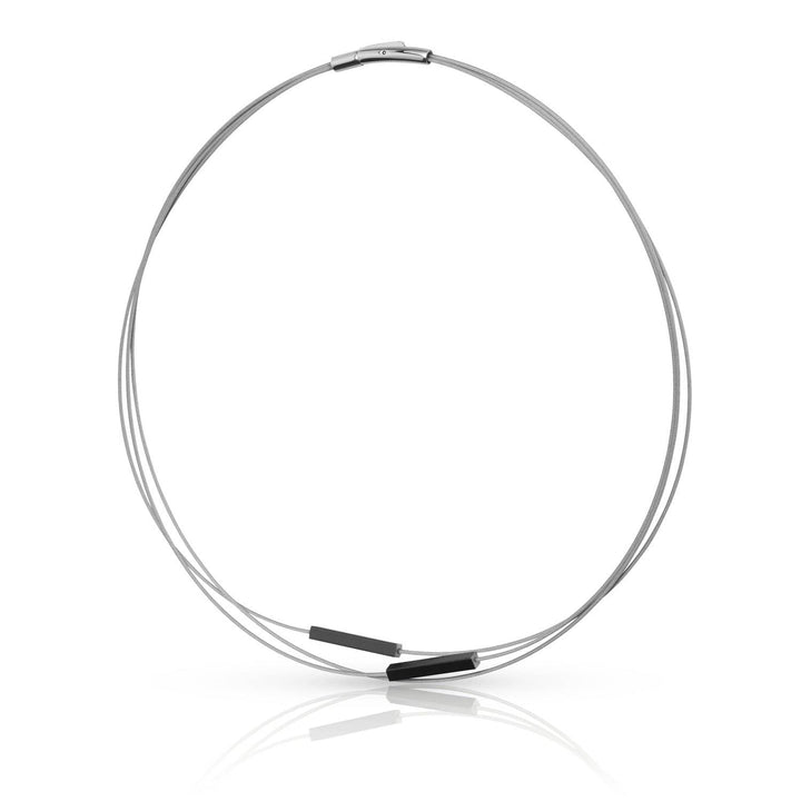 De Collier Staafjes Zwart C243Z van CLIC Creations is een minimalistische zilveren ketting met een delicate, dunne schakel en is voorzien van twee kleine, zwarte, rechthoekige hangers en een edelstalen bajonetsluiting, gerangschikt in een cirkel tegen een effen witte achtergrond.