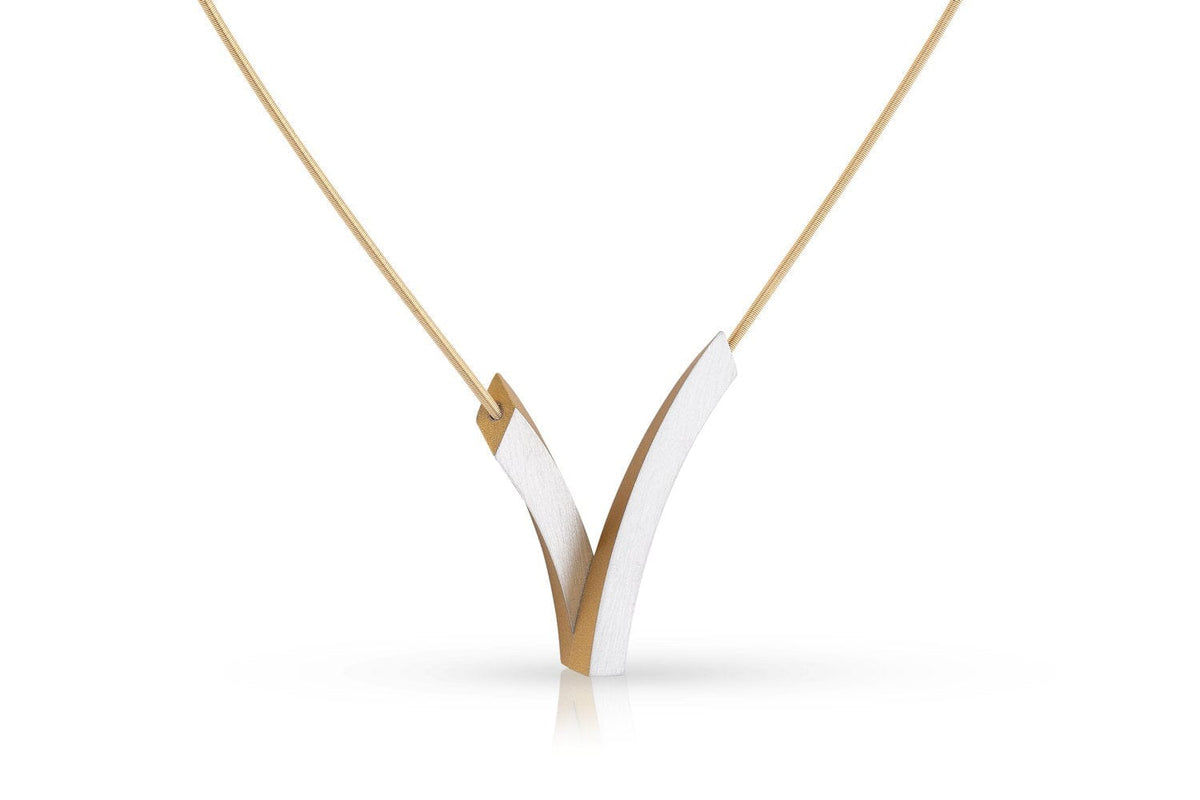 De Collier V-Bogen op elkaar Goud|Geel C255G van CLIC Creations is een minimalistische ketting met een strakke, V-vormige hanger met verweven goud- en zilvertinten. Hangend aan een dunne ketting met een magnetische sluiting, biedt het elegantie met scherpe, strakke lijnen.