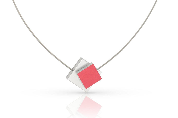 De Collier Vierkant met gekleurd vierkant C263R van CLIC Creations heeft een minimalistisch ontwerp met een geometrische hanger van overlappende zilveren en rode ruitvormige stukken aan een dunne metalen ketting. Het heeft een magnetische sluiting voor stijl en gemak tegen een schone witte achtergrond.
