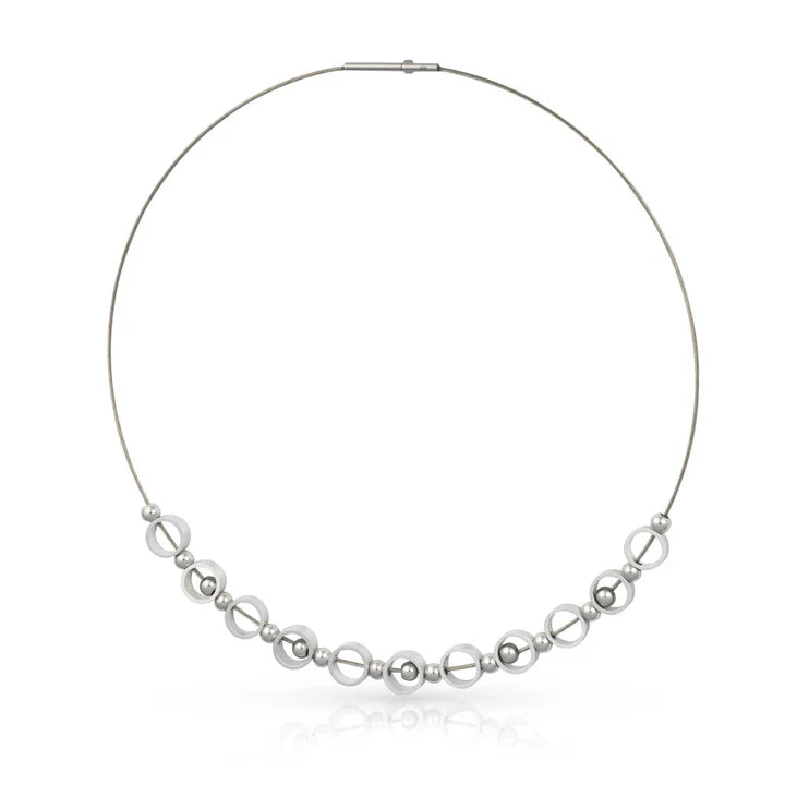 Collier argenté avec des perles rondes et des éléments en forme d'anneau.