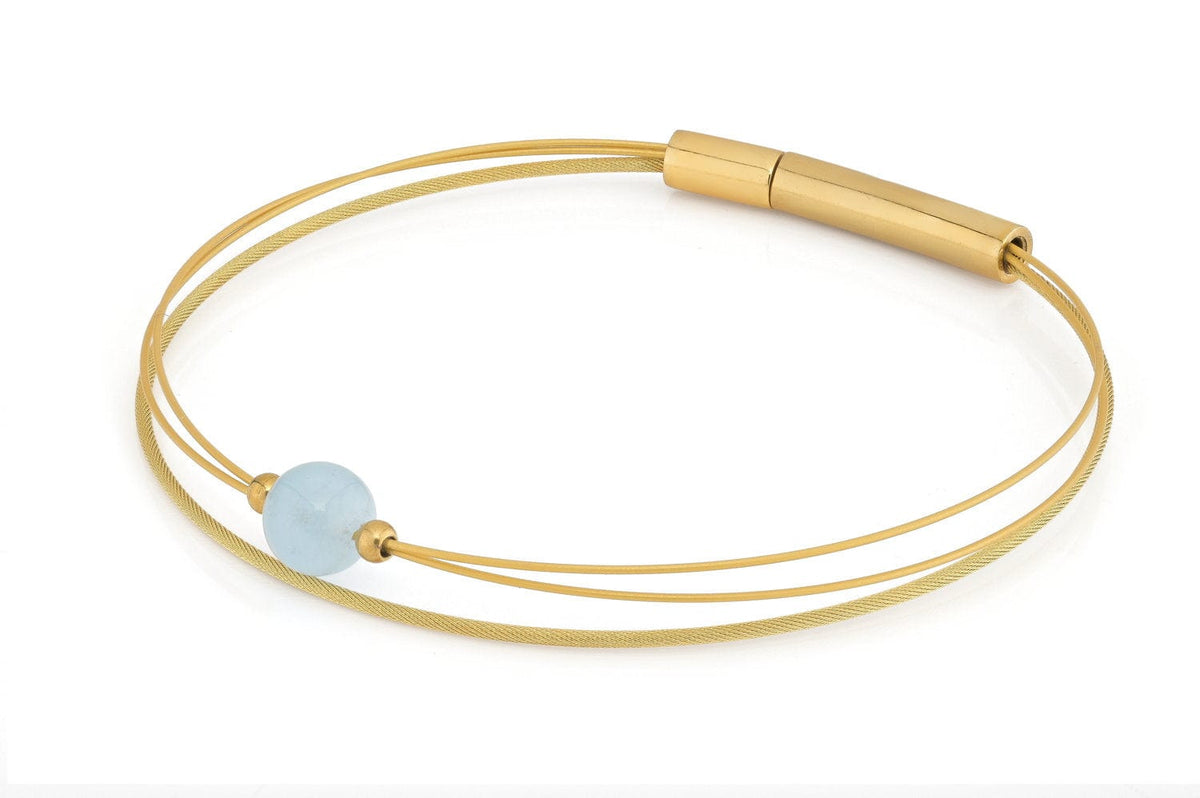 Bracelet doré avec une perle d'aigue-marine et un design minimaliste à double fil.
