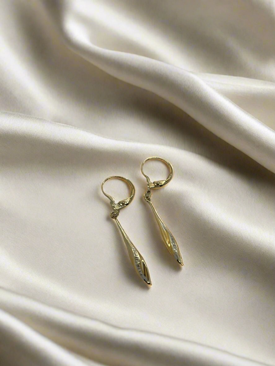 Boucles d'oreilles vintage en or 14k avec une forme allongée et un motif délicat.