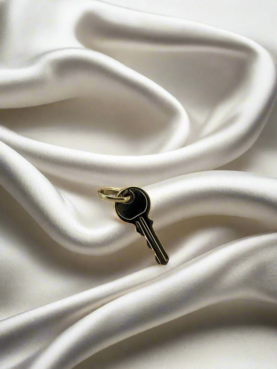 Vintage gouden hanger in de vorm van een sleutel, 14k, met een glanzende afwerking.