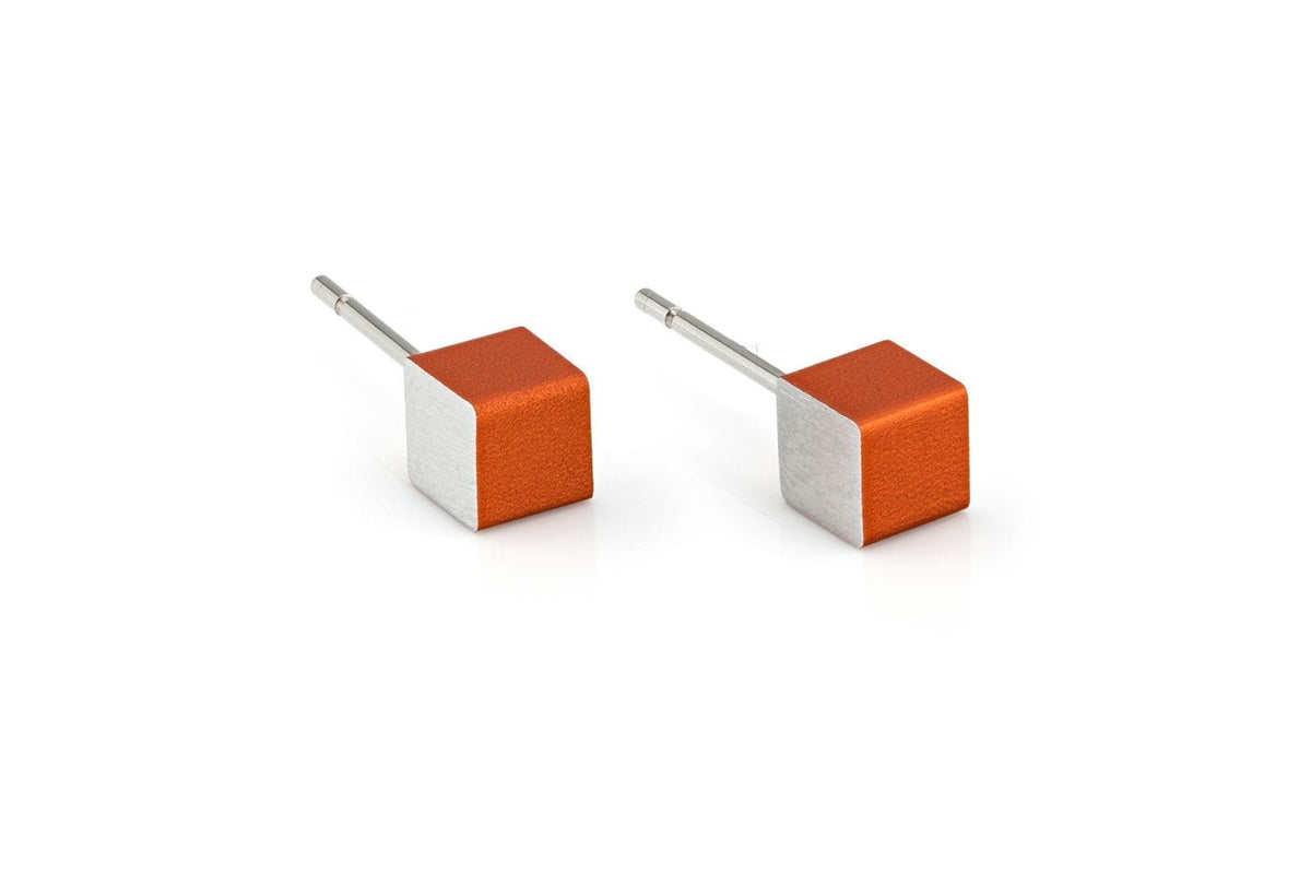 Boucles d'oreilles en forme de cubes orange et argentés.