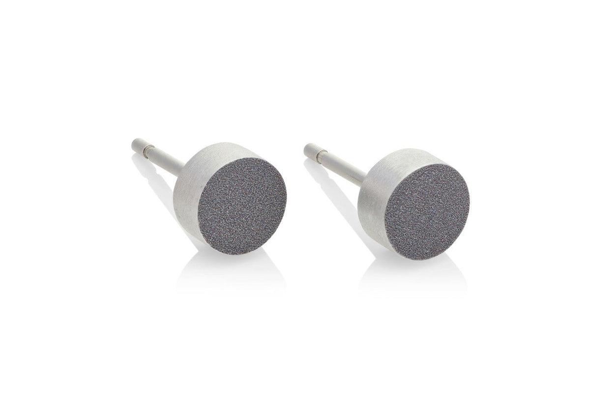 Boucles d'oreilles rondes en métal gris avec une finition mate.