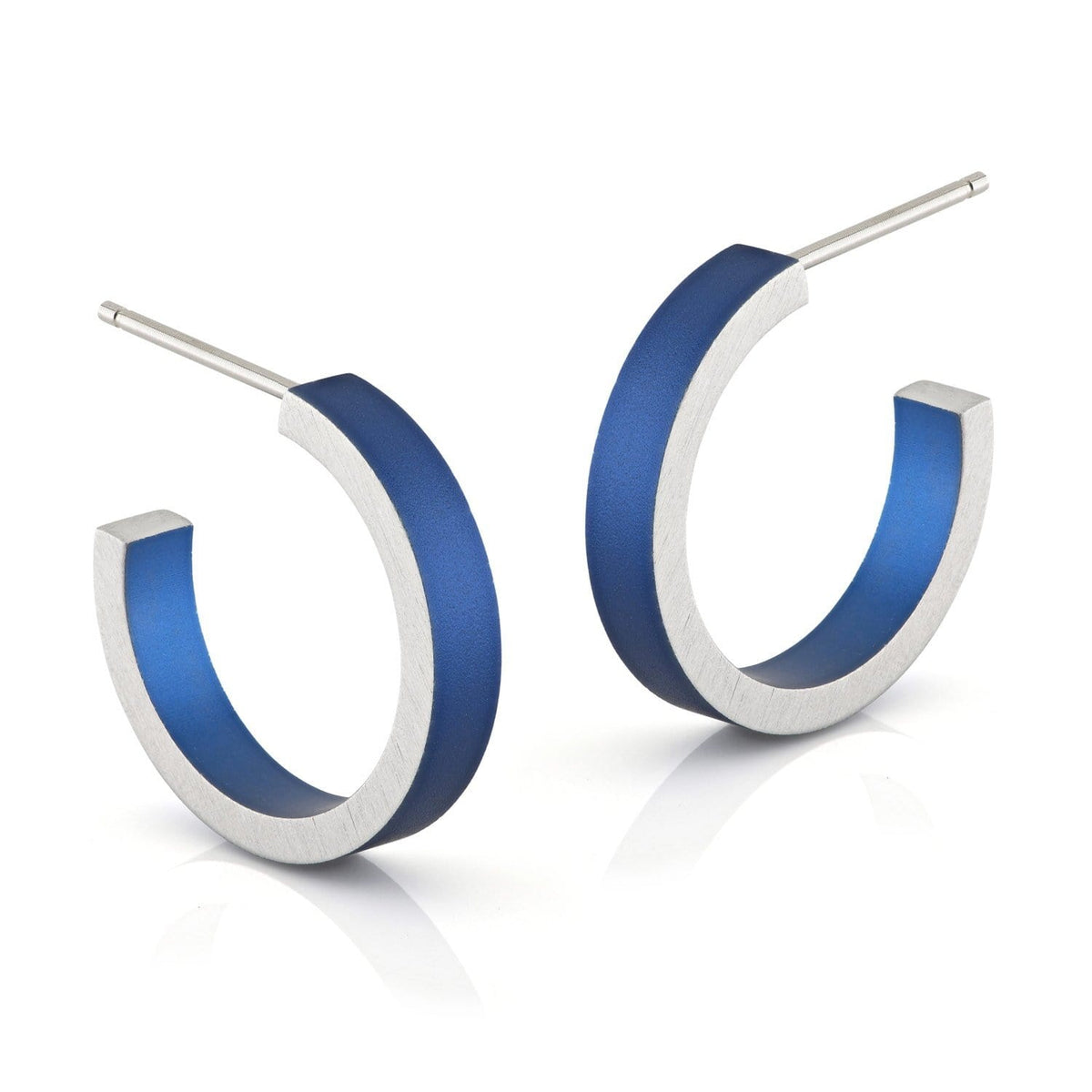 Boucles d'oreilles en forme de créoles, argentées avec une finition bleue.