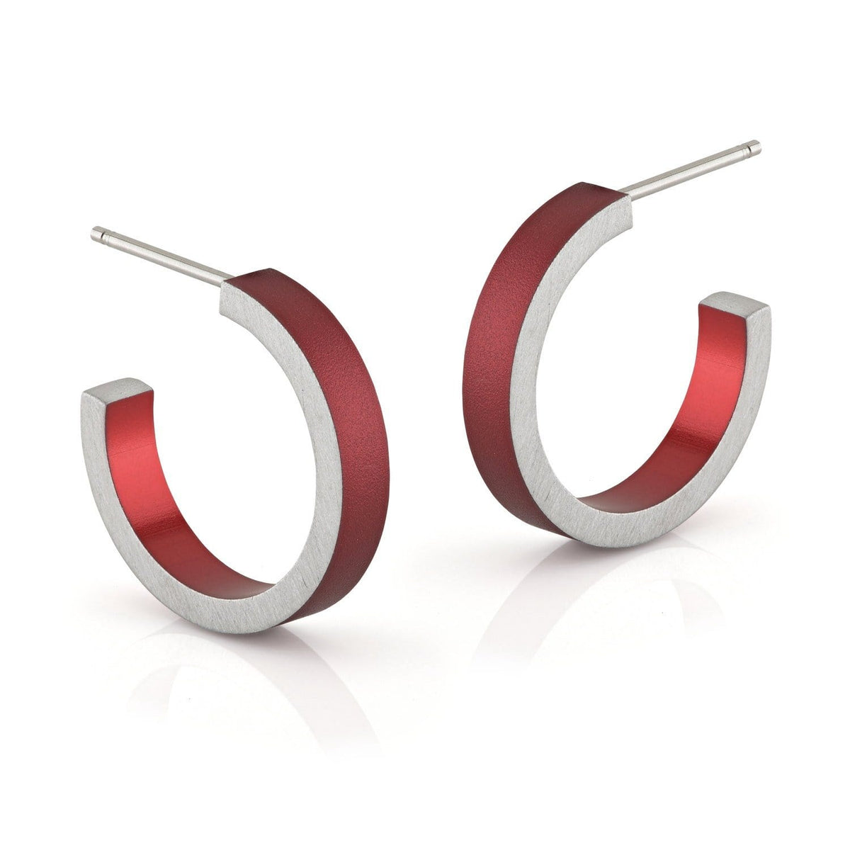 Boucles d'oreilles rondes en argent avec un intérieur rouge.
