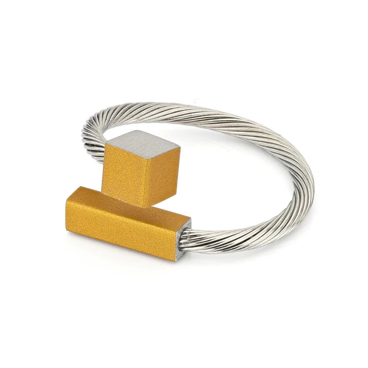 Bague en acier avec des éléments géométriques en jaune et argenté.