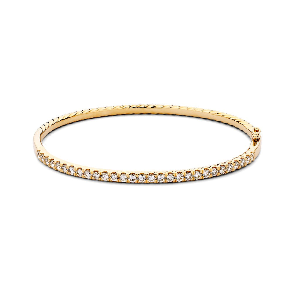Bracelet jonc en or jaune 14 carats, sertie de diamants, avec un design délicat.