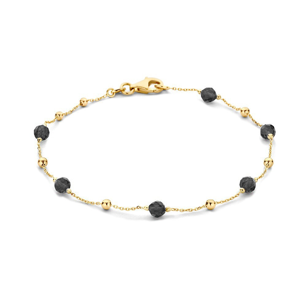Bracelet en or jaune avec des zirconias et des perles noires.